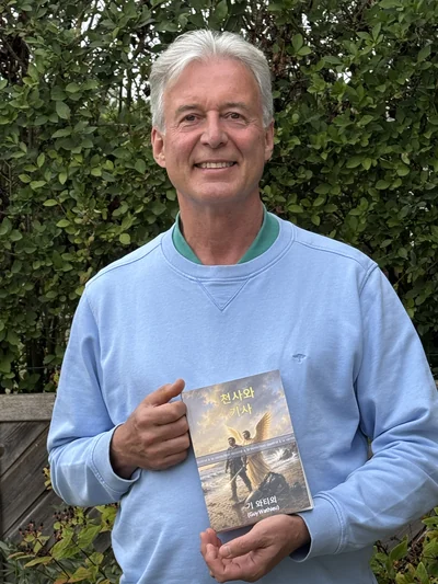 Guy Wathieu tient dans ses mains l’édition coréenne de L’ange et le chevalier.