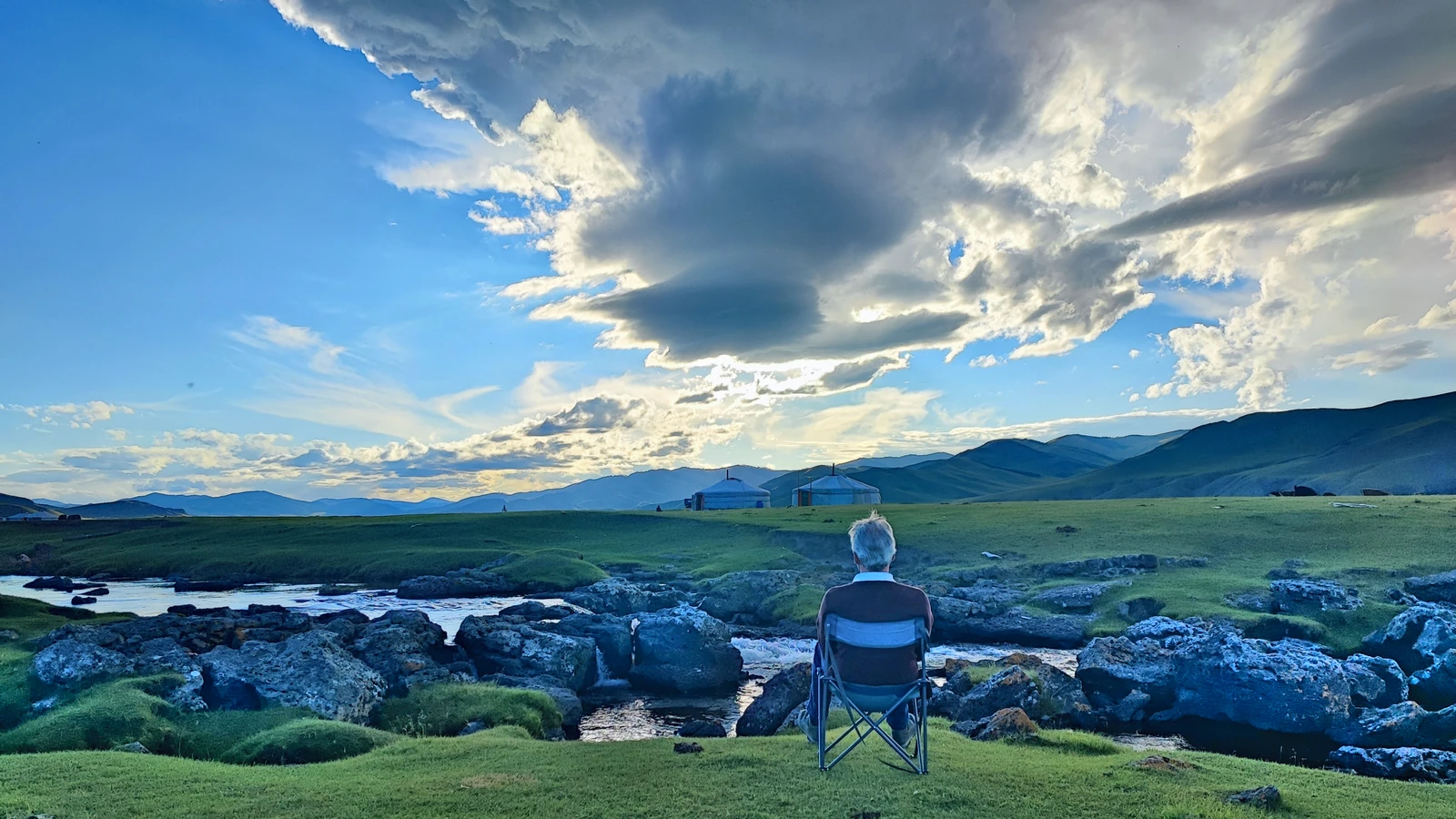 Guy Wathieu seated before a Mongolian landscape in 2022.