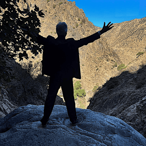 Guy Wathieu de dos face à une montagne les bras grand ouvert. Symbole d'unité et de puissance. Exploration de son monde intérieur